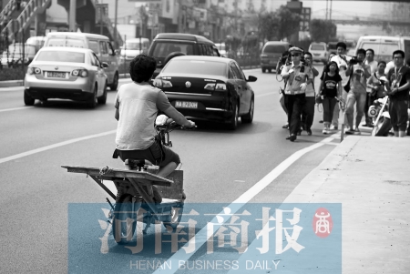 剛駛出隧道口，騎電動(dòng)車的他被交警攔下 邱曉峰/攝