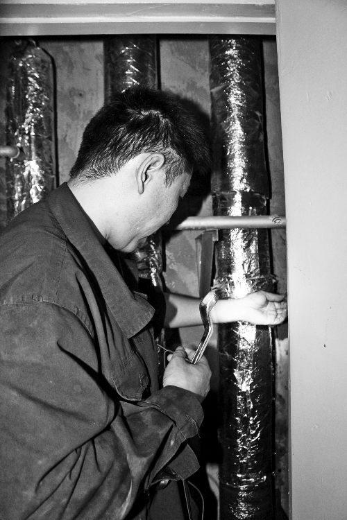 苗師傅一邊進(jìn)行維修，一邊用耳機(jī)接聽市民的電話。