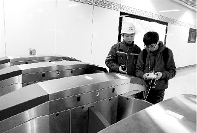 昨天上午，體育中心站，工作人員正在對進出站閘機進行調(diào)試。