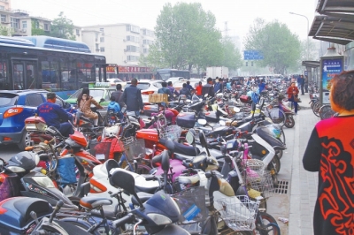 省人民醫(yī)院北門，路邊的公交站牌處停滿非機(jī)動(dòng)車，上、下客只能在快車道上。