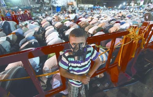 當(dāng)?shù)貢r(shí)間28日晚，在埃及開羅納賽爾城，一名小男孩頭戴防毒面具參加穆兄會(huì)的集會(huì)示威。