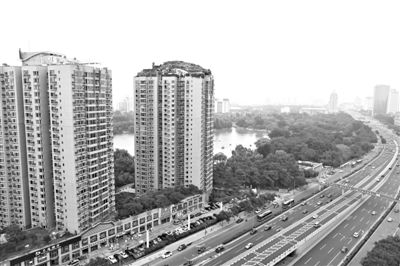 昨日，人濟(jì)山莊小區(qū)，與其他樓相比，B棟樓頂層天臺上違規(guī)建造了一棟兩層小樓，假山大樹俱全。新京報(bào)記者