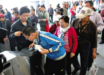 去年5月5日，14號線園博園站，乘客刷卡出地鐵。北京公交地鐵將實(shí)行計(jì)程票制，多乘坐多付費(fèi)。