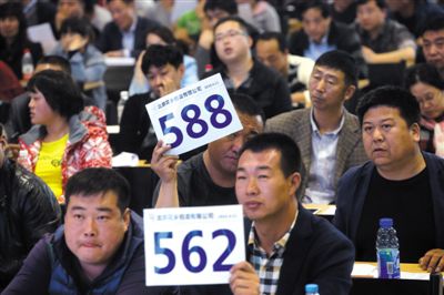 昨日，拍賣現(xiàn)場競拍者舉牌競拍。新京報記者