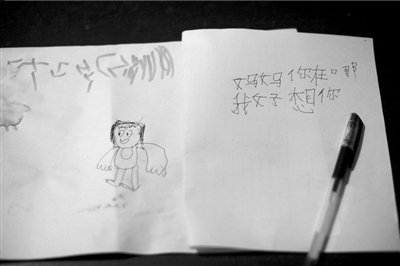 名叫袁明燕的小姑娘用筆在紙上不斷寫“媽媽”二字。