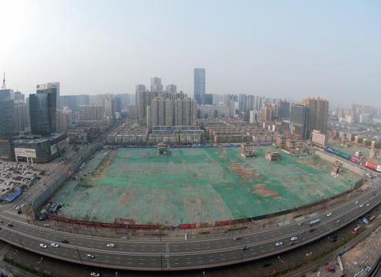 2016年4月，經(jīng)過持續(xù)攻堅，親賢社區(qū)西北片區(qū)的拆遷工作基本告一段落，但在鋪設了防塵綠網(wǎng)的空地中，至今仍有3戶居民選擇了“堅守”。(拍攝：2016年4月4日)