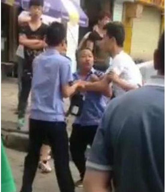付某（右）與城管執(zhí)法人員廝打在一起。