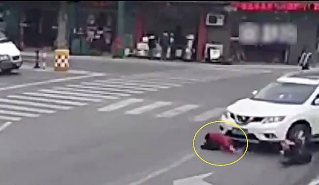 圖為小姑娘被卷進(jìn)車輪下瞬間。