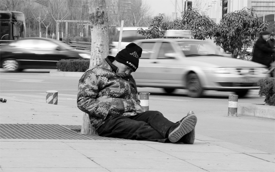 2月2日，鄭州市中州大道農(nóng)業(yè)路立交橋下，50歲的王文德打算在臨近春節(jié)前再接些零活兒，由于疲憊，他睡著