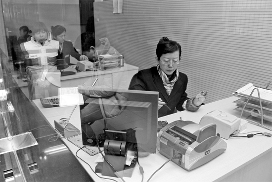 2月16日，鄭州市自來水總公司鄭東新區(qū)一營(yíng)業(yè)廳，柜臺(tái)內(nèi)工作人員正在為市民辦理業(yè)務(wù)