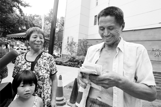 昨日，鄭州市明達(dá)路與豐慶路交叉口西300米路南，來自中牟的瓜農(nóng)拿到西瓜款，笑開顏東方今報(bào)記者袁曉強(qiáng)