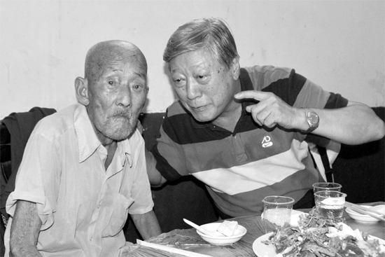 昨日，來自北京的英雄后代胡冠軍（右）專門趕到西平縣看望抗戰(zhàn)老兵孫殿修老人