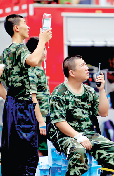 火場外，被消防戰(zhàn)士稱為“李大隊”的救援人員掛著吊瓶現(xiàn)場指揮