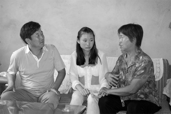 “商丘最美女兒”李丹（中）捐骨髓救母，愛心人士（左）送來1萬元愛心款