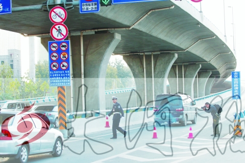 交警在東風(fēng)路從北向南上橋口處擺上反光錐，間歇放行