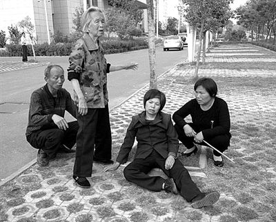 2013年4月28日，平頂山市市政府附近，受害者郭小蕊（化名）的家屬鳴冤，郭小蕊的母親杜玉花癱坐在地上。