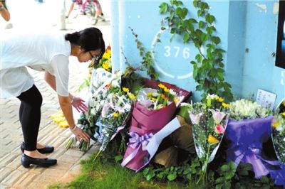 6月8日下午，記者來到廈門公交車爆炸事發(fā)現(xiàn)場橋下，附近已聚集了十幾個(gè)自發(fā)前來悼念的市民。橋墩下排放了一圈或黃或白的菊花，還有玖瑰、百合等。