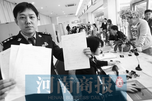 　民警左手拿的是新申請表，右手拿的是三份老申請表 王春勝/攝
