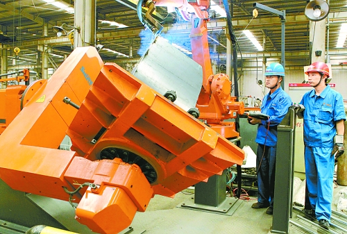 圖為龍工集團(tuán)中原公司的職工正在操作機(jī)器人焊接裝載機(jī)。