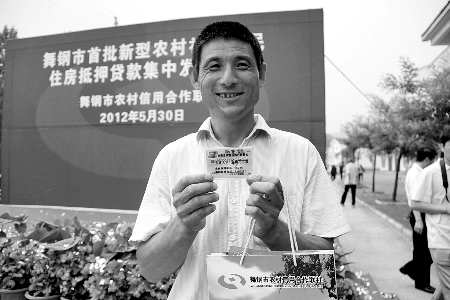 領到貸款，農(nóng)民開心地笑了。