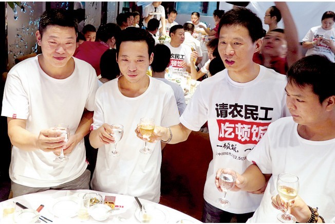 活動(dòng)發(fā)起人張楠（右二）給農(nóng)民工敬酒。