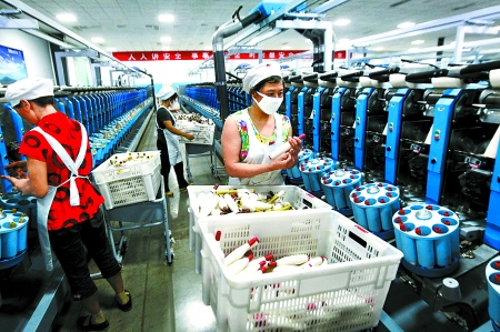 6月6日，舞鋼市鑫海紡織有限公司員工正在新建成的紡紗車間生產(chǎn)。