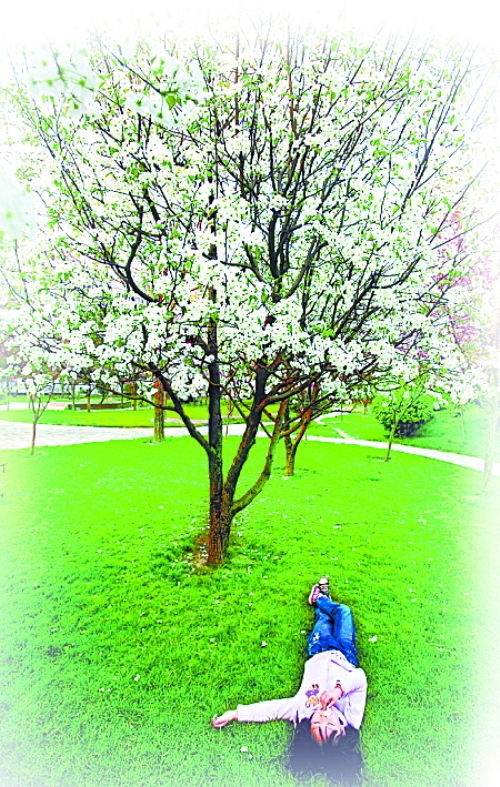 　孩子愜意地躺在社區(qū)內(nèi)的草坪上。