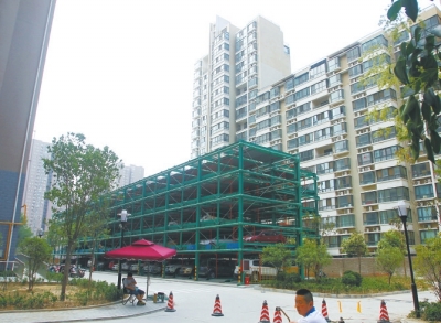 商城路與英協(xié)路交叉口附近的濱河綠苑小區(qū)內，剛剛建好一個立體停車場。
