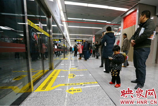 小朋友在等候區(qū)內(nèi)等待地鐵。