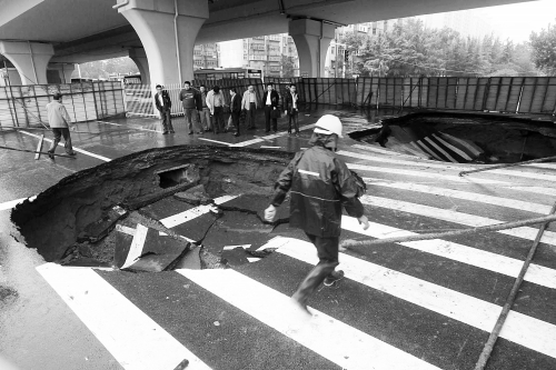 中原路西三環(huán)立交橋下由南向北原本4個車道，由于塌坑，而今3個車道被圍擋
