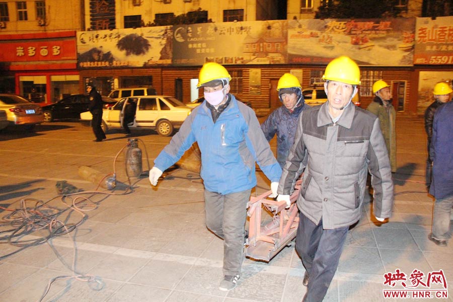 23點56分，第一塊兒廣告牌已經(jīng)分割完畢，地面上的20多名工人將拆除下來的鋼件撞車運走。