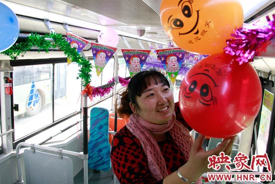 鄭州快速公交B3區(qū)間線車長李鵬云在車廂里懸掛氣球，布置圣誕車廂，營造歡樂圣誕氛圍