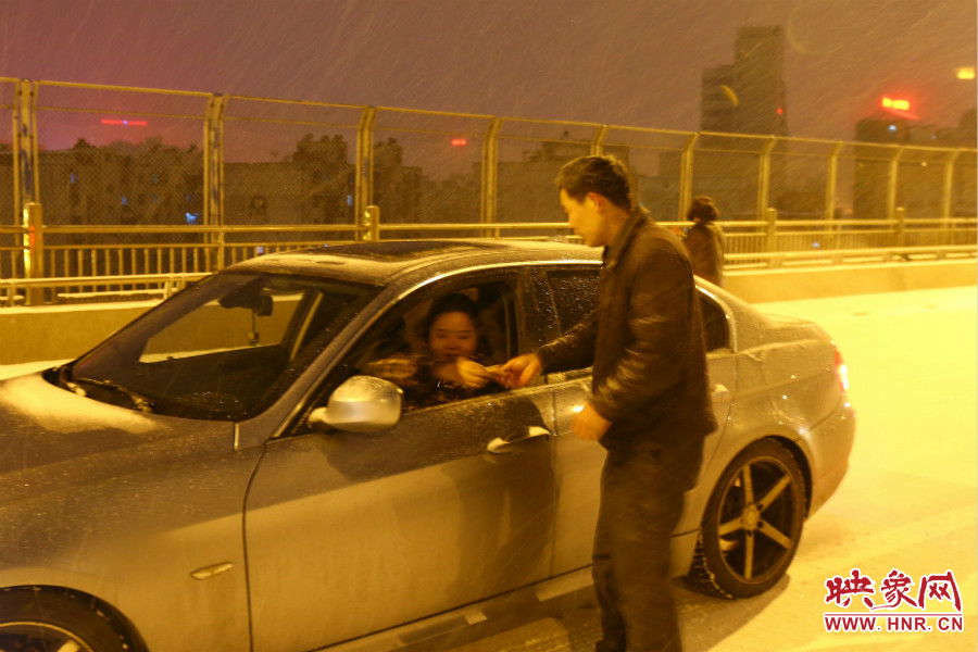 “推車(chē)人”幫助一輛車(chē)上坡后，收取“勞務(wù)費(fèi)”。