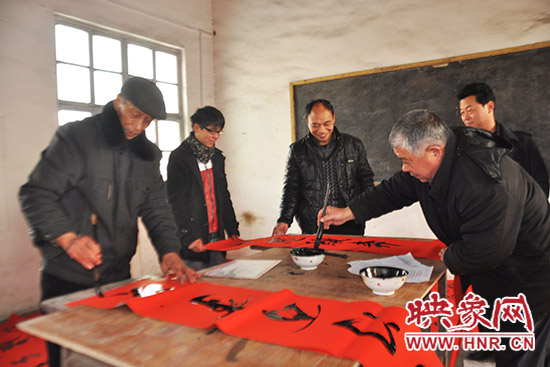 鞏義市魯莊鎮(zhèn)農(nóng)民書法愛好者正在寫春聯(lián)。