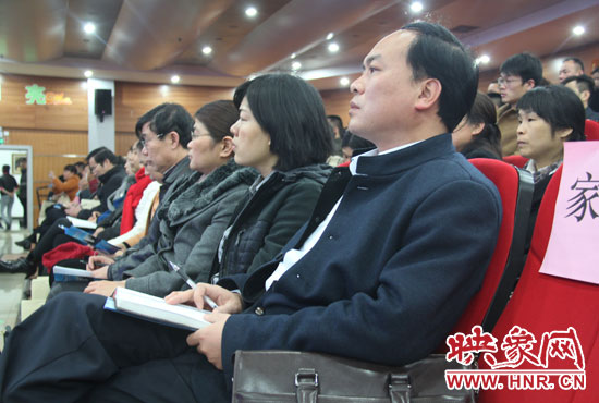 認(rèn)真聽取招生政策的學(xué)生家長。