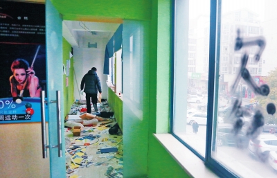 　健身會所地上一片狼藉，玻璃上噴著黑色“欠錢”二字。