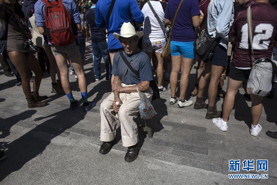 一名男子坐在參加不穿褲子搭地鐵的人群邊小憩。