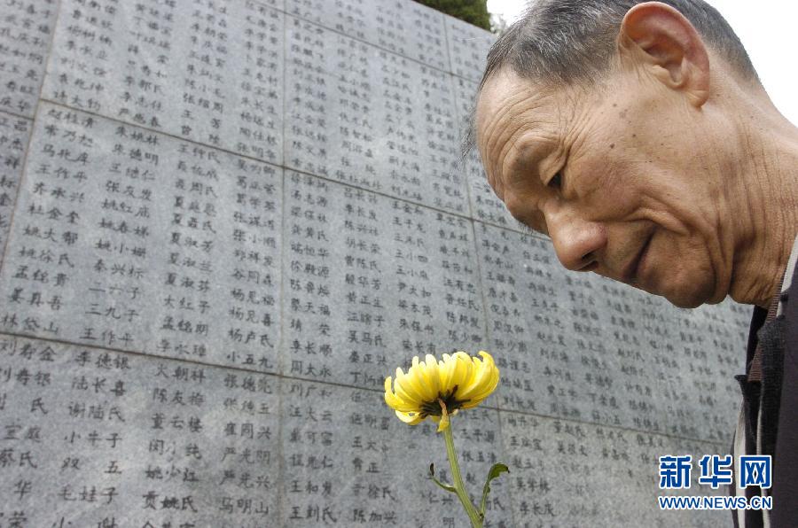 2006年4月5日，74歲的南京大屠殺幸存者佘子清手捧鮮花，祭奠被日軍殺害的母親。