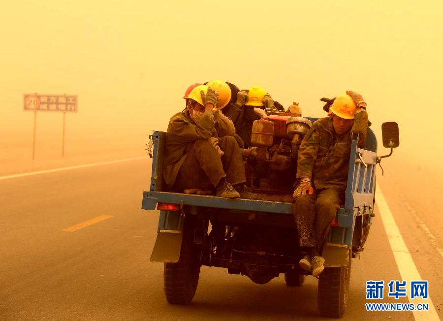 4月23日，一輛拉載公路施工人員的三輪車在沙塵暴中行駛在酒泉市瓜州縣城郊的公路上。