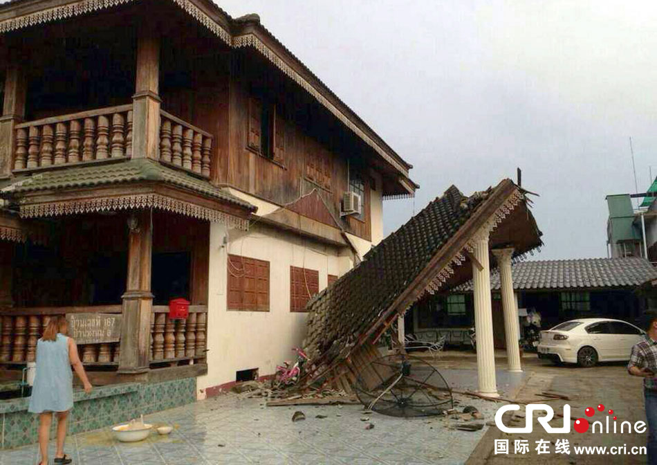 當?shù)貢r間2014年5月5日，泰國清萊，一名婦女看著受損的房屋。 圖片來源：東方IC