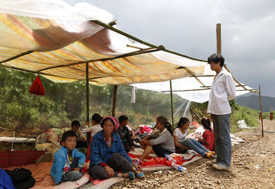暴雨馬上來臨，村民們在簡易帳篷下躲雨。澎湃新聞 程藝輝 圖