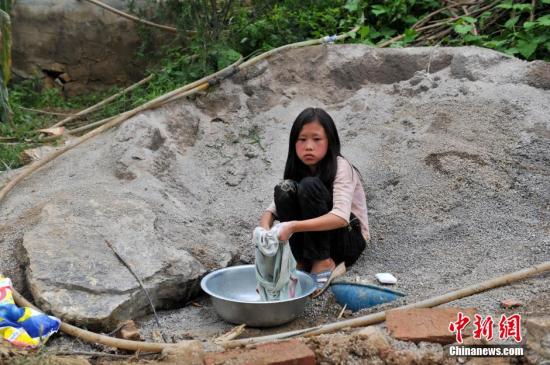8月9日，云南巧家紅石巖村，10歲的劉鑫蕊在洗自己的衣服