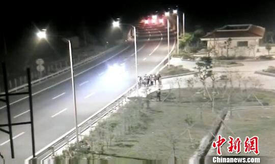 看到車輛經(jīng)過(guò)，孩子們便急忙跑到一旁的花圃上?！【焦﹫D　攝