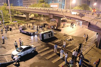 路虎沖下國貿(mào)橋砸中一輛起亞轎車，橋上厚達幾十厘米的水泥護欄被撞斷，碎石四處散落，數(shù)十群眾在現(xiàn)場圍觀。