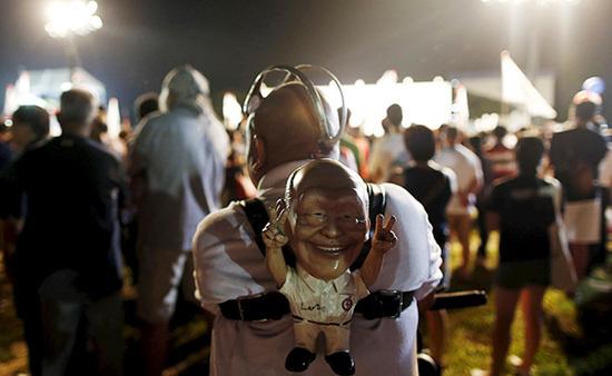 9月4日，新加坡，執(zhí)政黨的一場(chǎng)集會(huì)上，一名支持者背著一個(gè)李光耀的人偶。