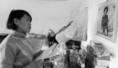 錢仁鳳站在母親遺像前。未能見母親最后一面是她的一大遺憾。