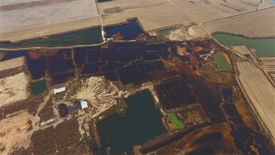 4月19日，廊坊市大城縣南趙扶鎮(zhèn)，津保路以北約八九百米處，一個巨大的污水坑中，水體呈現(xiàn)紅褐色。 新京報記者 尹亞飛 攝