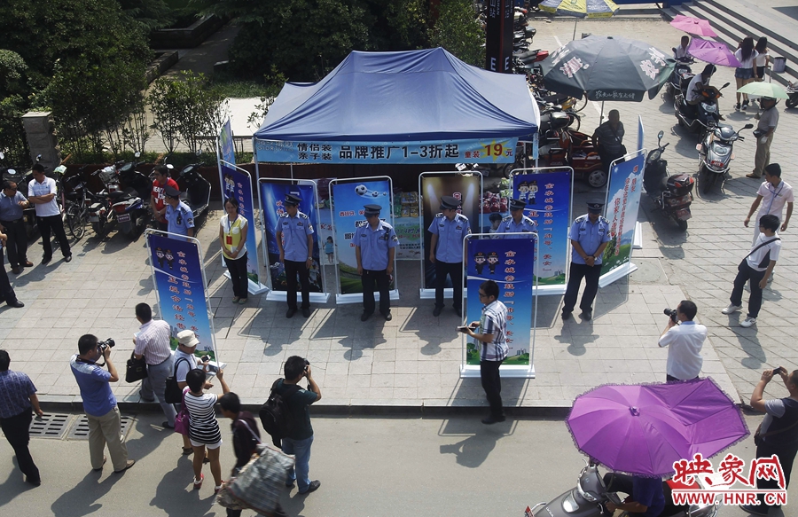 執(zhí)法人員用宣傳牌圍擋占道經(jīng)營攤位。