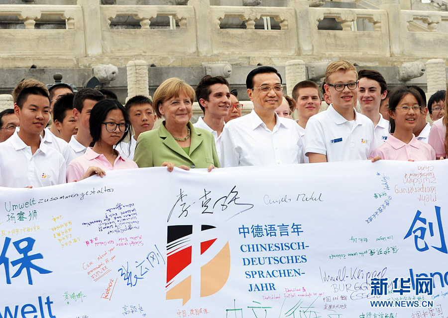 李克強(qiáng)同默克爾與青少年在天壇祈年殿前合影留念。