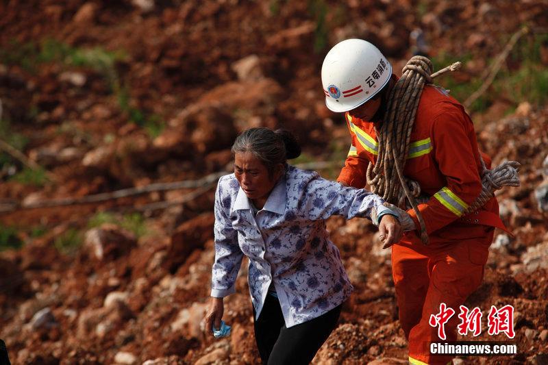一位消防戰(zhàn)士將一位失去親人的老人扶離滑坡點(diǎn)。